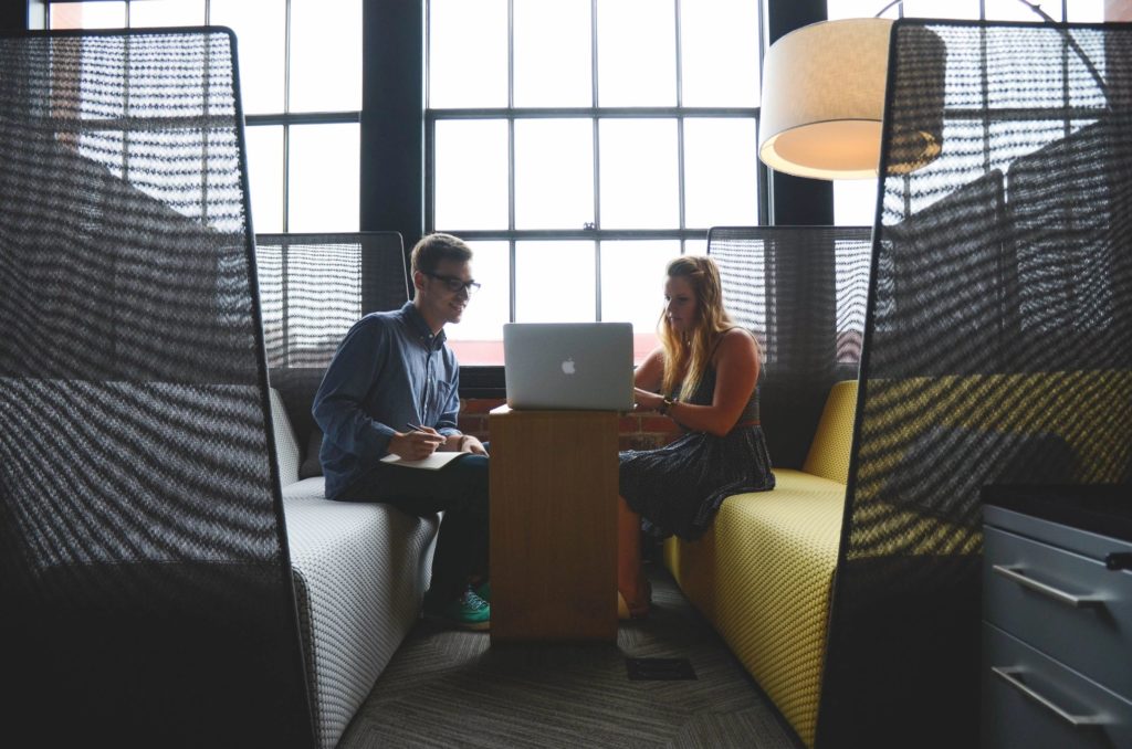 Getting benefit from your benefits - employees look at shared laptop.