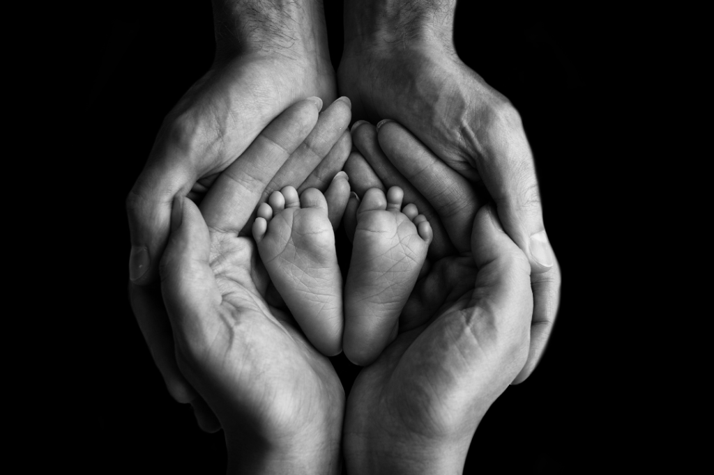 Preparing for parental leave and return to work - parents holding baby feet in their hands.