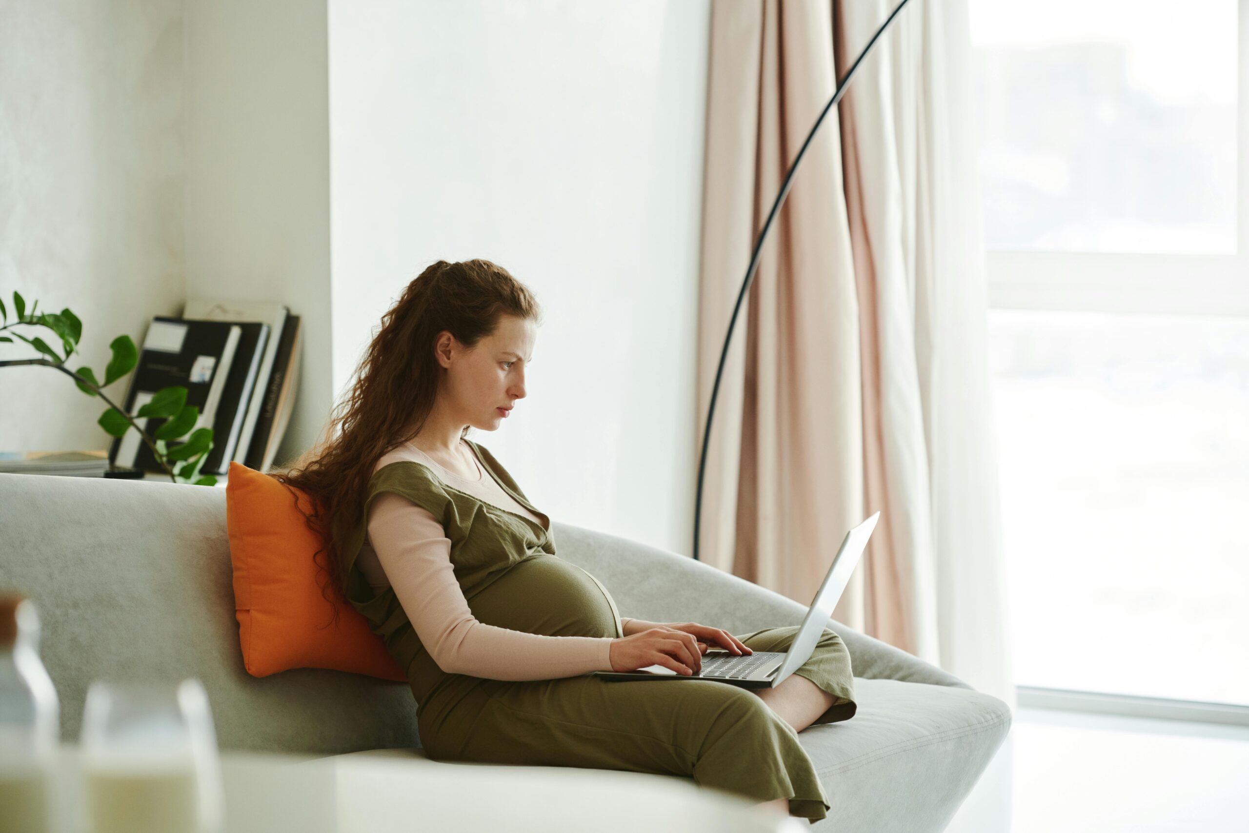 What to know before maternity leave - pregnant woman working on laptop