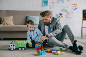 Work life balance is possible when you have a baby - Father in a business suit plays with his son after work